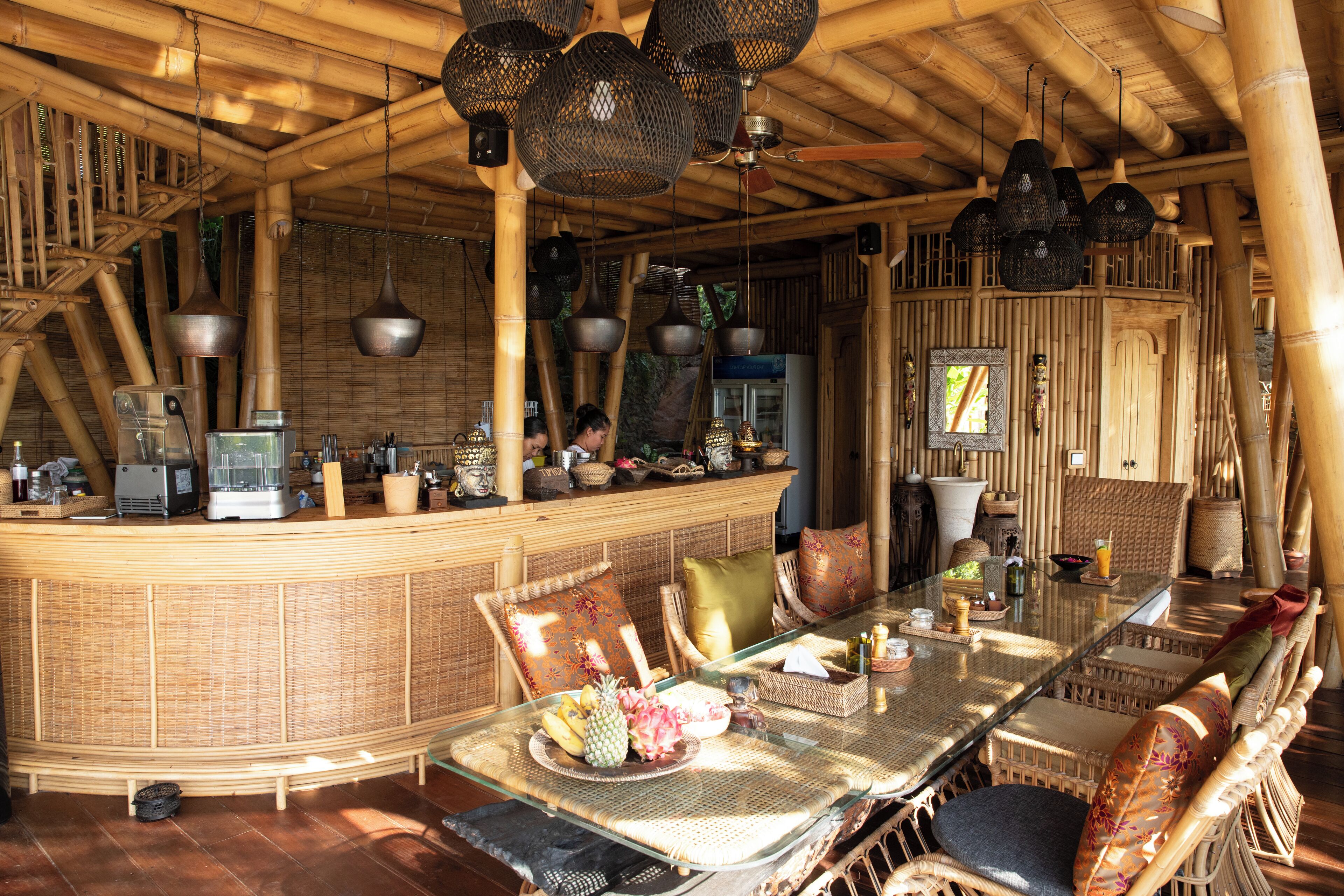 Arredamento a tema bamboo con zona bar, mobili in vimini e lampade a sospensione.