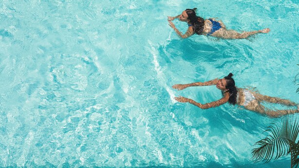 An aerial view of a swimming pool with two individuals swimming. - Lum Residence (Ahangama)