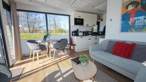 Een moderne woonkamer met een bank, een salontafel en een eethoek met stoelen en een tafel.
