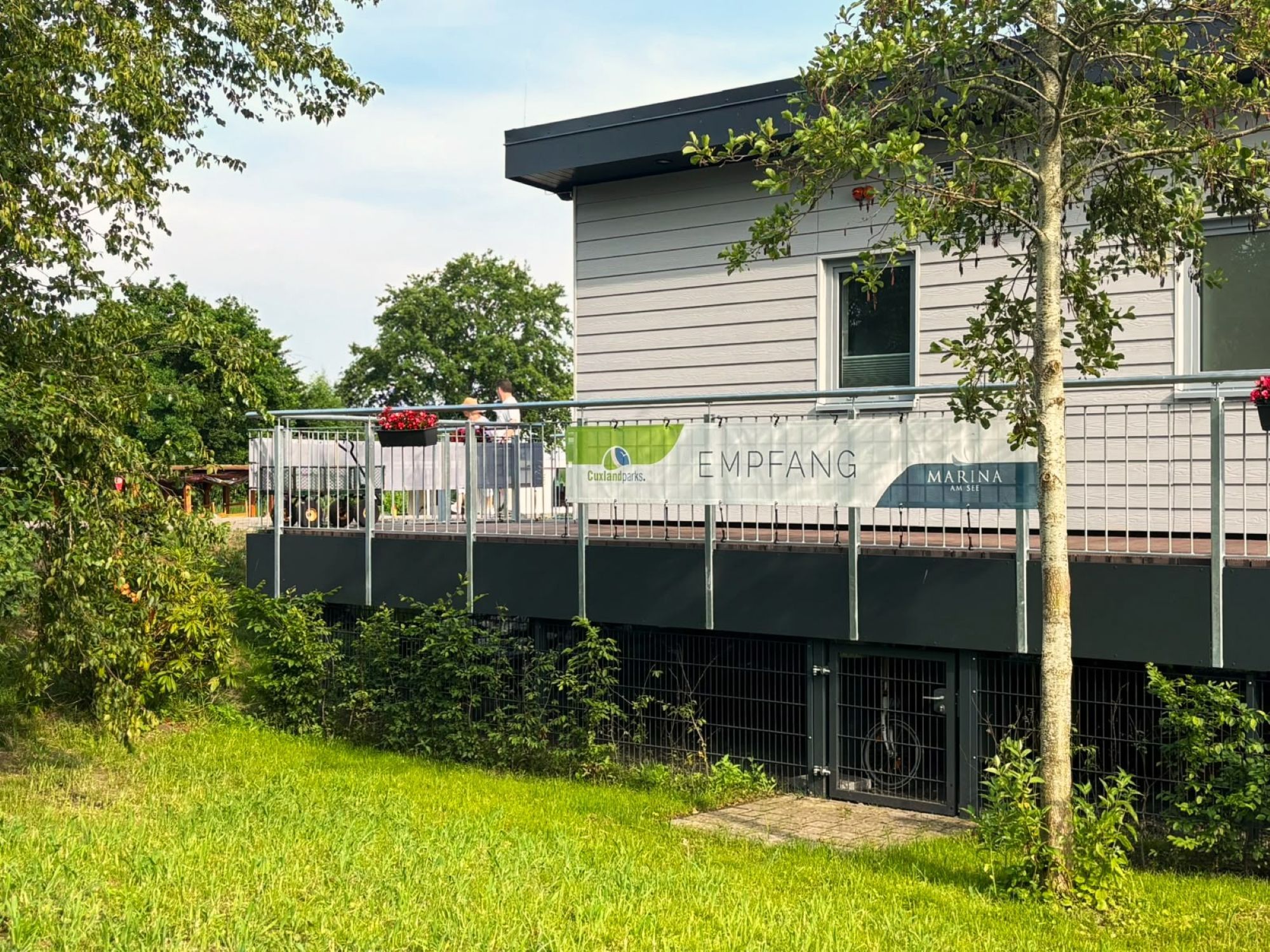 A building with a sign that reads 'EMPFANG' and 'Marina AM SEE'.