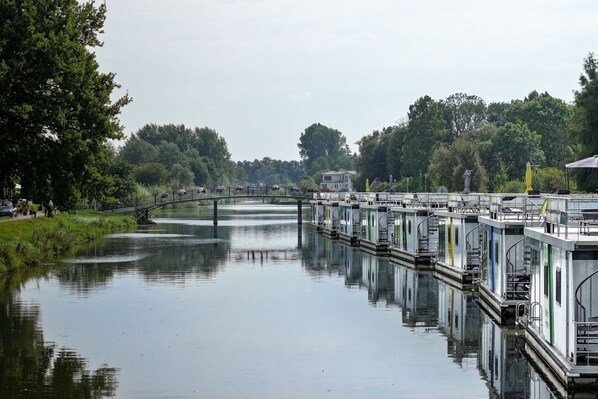 A calm river with a bridge and floating structures.