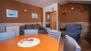 Ein modernes Wohnzimmer mit einem runden Holztisch, zwei Sofas und einem kleinen Beistelltisch.