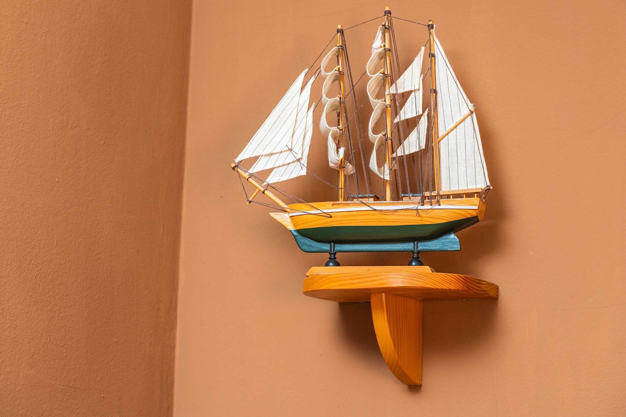 Un modelo de velero de madera montado en una pared.