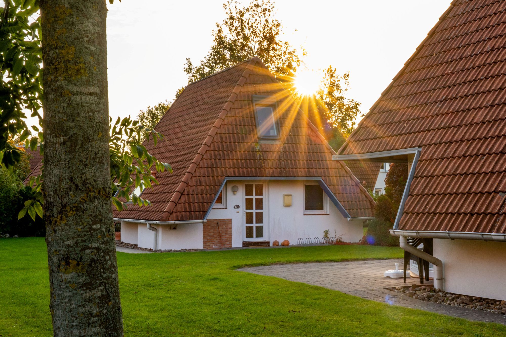 Ein traditionelles Haus mit einem geneigten Dach, einer Haustür und einem sichtbaren Schornstein.