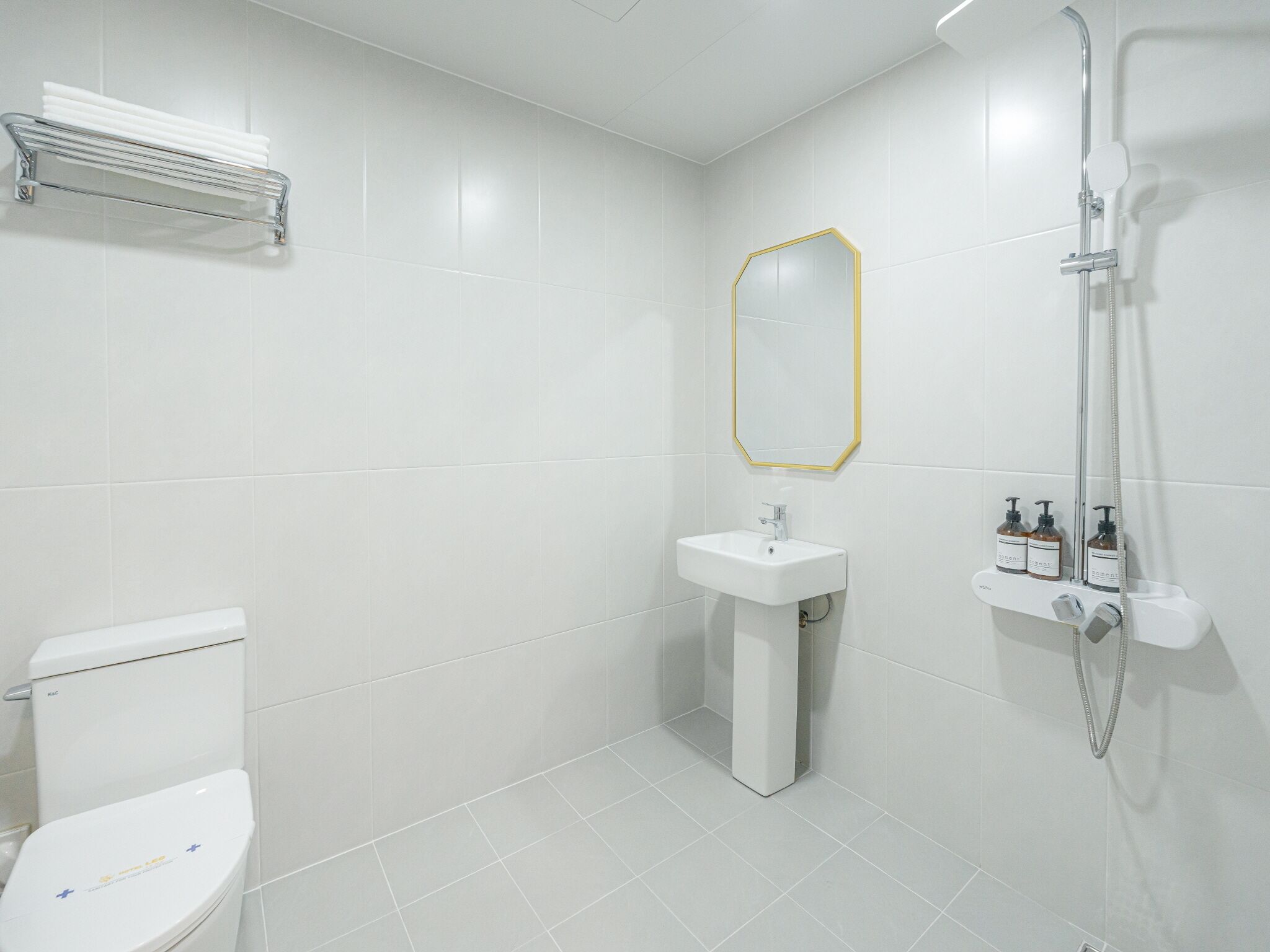 A modern bathroom with a toilet, sink, and shower.