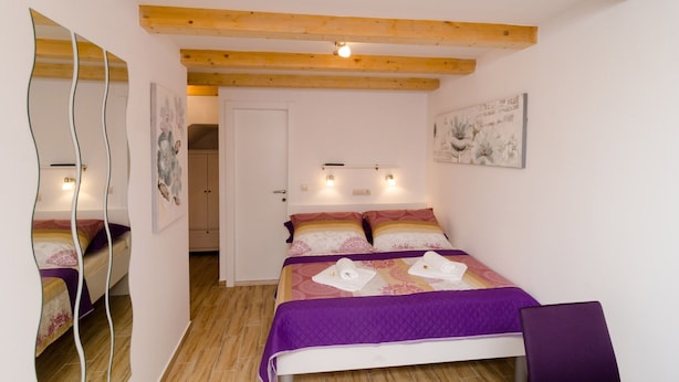 Ein Schlafzimmer mit einem Bett, einem Spiegel und einer Tür.