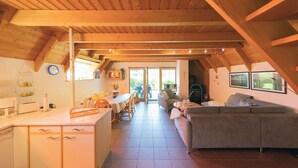 A cozy attic room with a kitchen, dining area, and living space. - Vacation home Kniepsand 7 with sun terrace and comfortable. (Wurster Nordseeküste)
