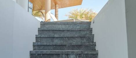 A staircase leading up to a wooden ceiling structure.