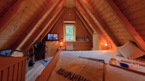 A cozy attic bedroom with a bed, a desk with a computer, a chair, and a TV. - Vacation home Medemsand 1, idyllic and in the middle of the action. (Wurster Nordseeküste)