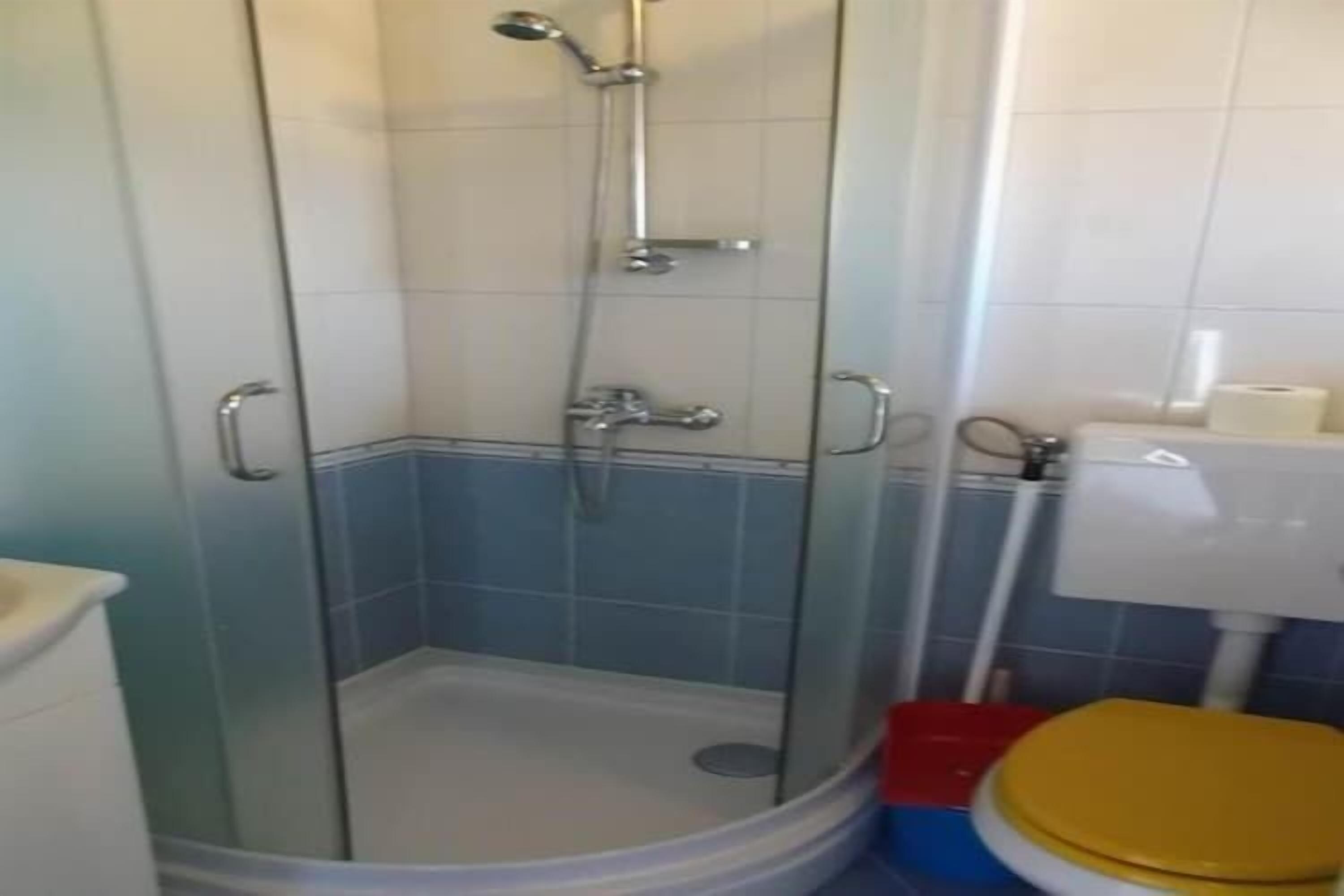 Een badkamer met een douchecabine, een toilet en een wastafel.