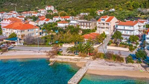 An aerial view of a coastal town with buildings, a beach, and a pier. - Villa Ponar with Swimming Pool (Kuciste)