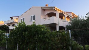 A two-story building with a balcony and a chimney.