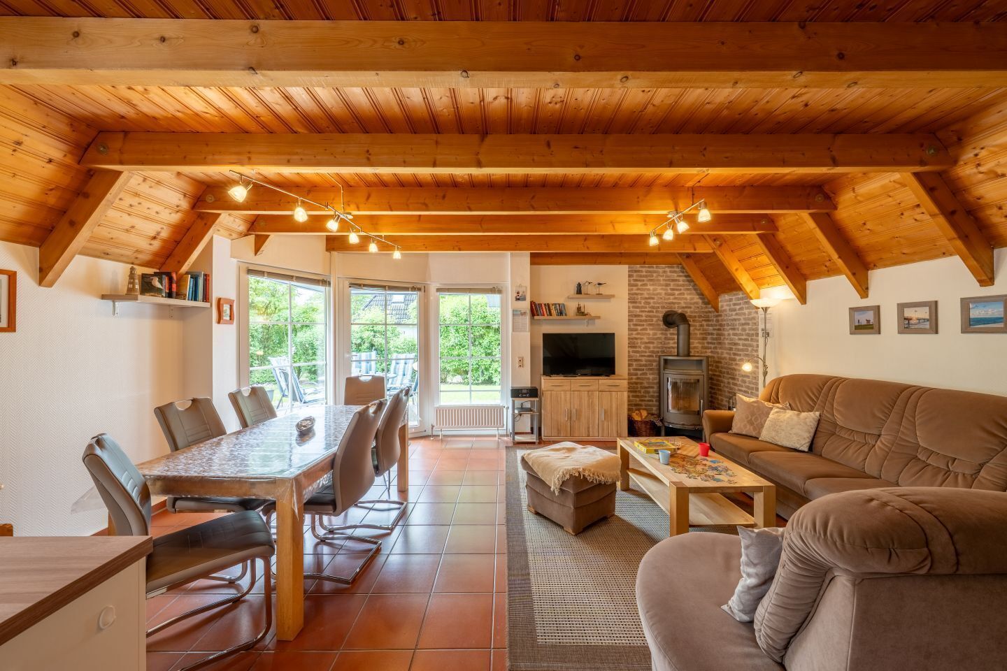 Een knus interieur van een chalet met een eethoek, bank en open haard.