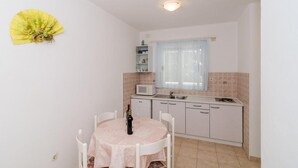 A small kitchen with a dining table, a microwave, and a sink.