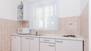 A compact kitchen with a microwave, sink, and cabinets.