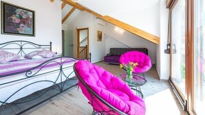 A bedroom with a bed, a bright pink chair, a small table with flowers, and a window with a view. - Villa Mia -Three-Bedroom Villa with Swimming Pool (Trsteno)