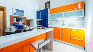 A modern kitchen with orange cabinets, a white countertop, and stainless steel appliances. - Villa Mia -Three-Bedroom Villa with Swimming Pool (Trsteno)