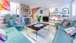 A modern living room with teal sofas, a glass coffee table, and a fireplace. - Villa Mia -Three-Bedroom Villa with Swimming Pool (Trsteno)