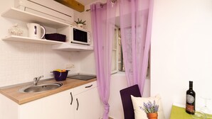 A kitchen with a sink, a microwave, and a potted plant. - Lavender Garden Apartments - Studio Apartment (Ground floor) - APT 1 (Dubrovnik)