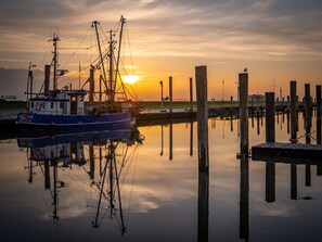 Un bateau était amarré à un quai, avec un coucher de soleil en arrière-plan.