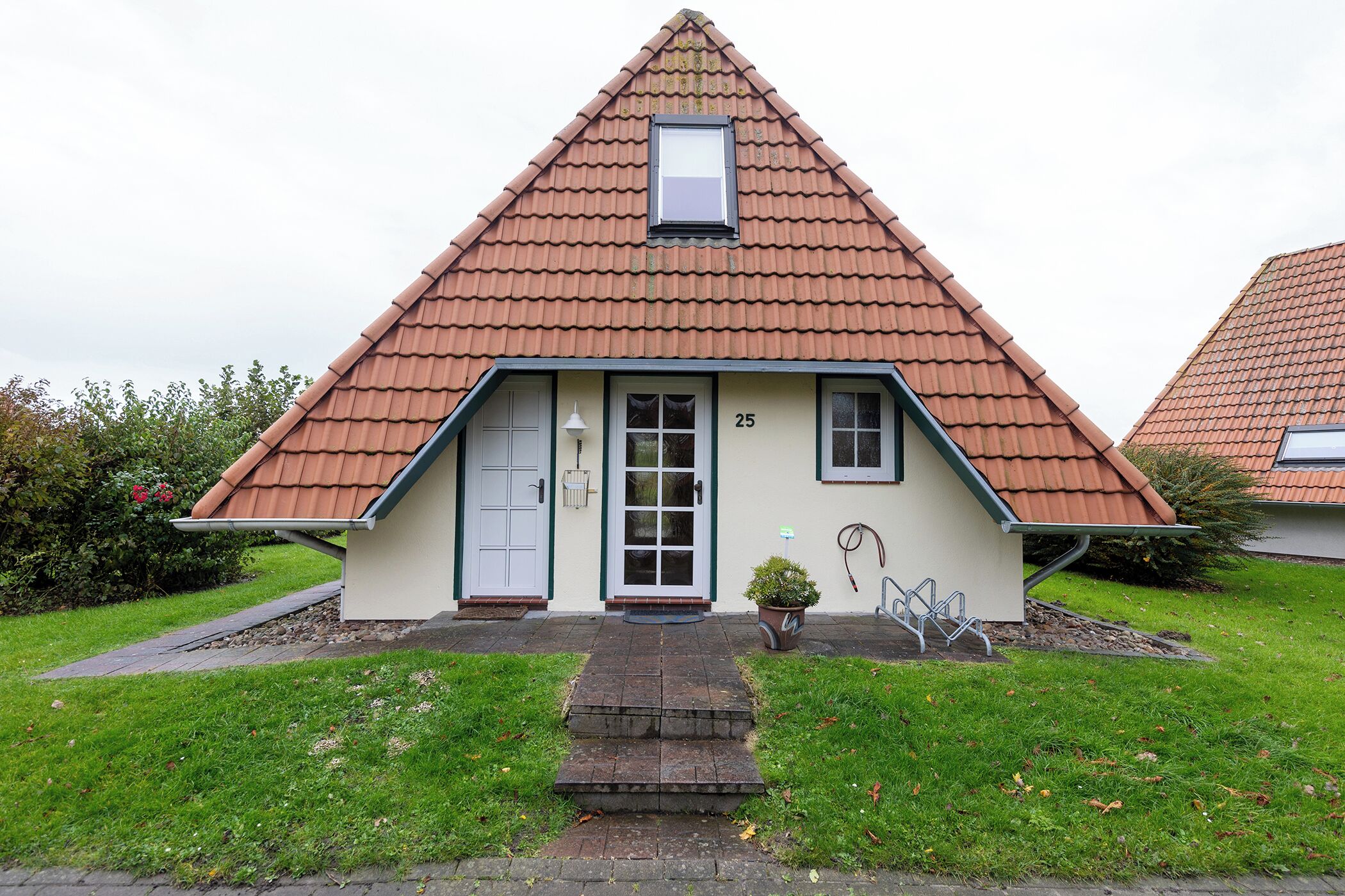 A house with a triangular roof, a front door, and a small window above the door.