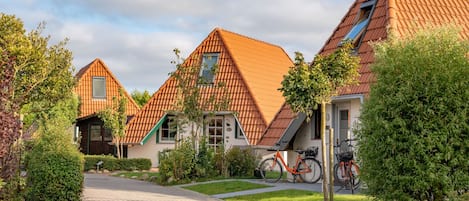 A residential area with houses featuring pitched roofs and a paved driveway.