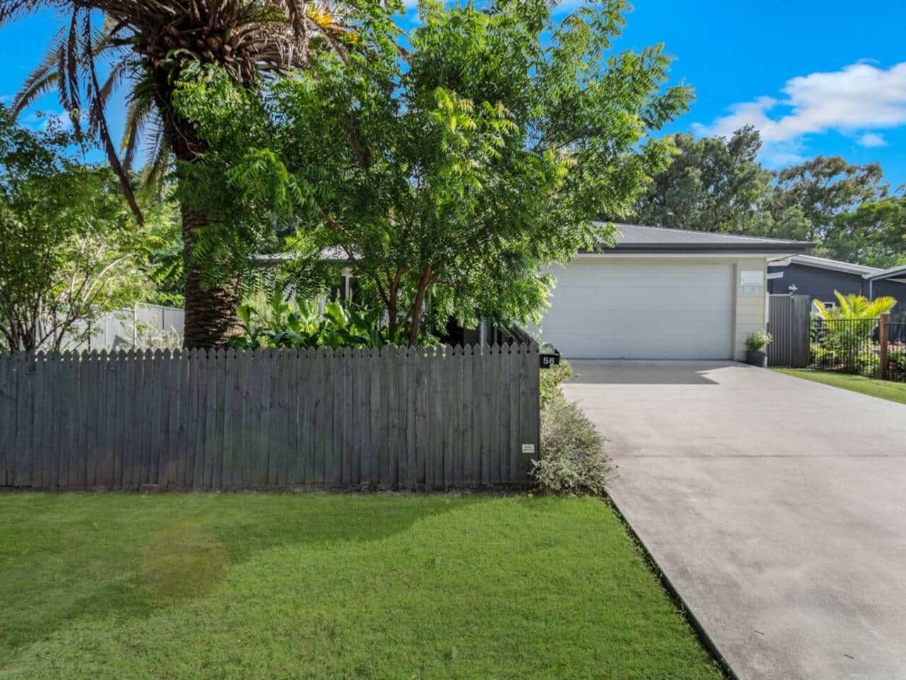 A residential property with a fenced yard, a garage, and a well-maintained lawn.