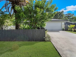 A residential property with a fenced yard, a garage, and a well-maintained lawn.