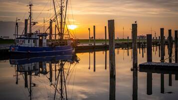 A boat docked at a pier with a sunset in the background.