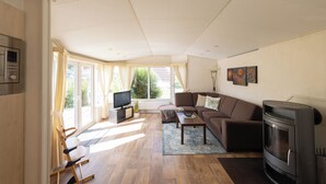 Ein Wohnzimmer mit Sofa, Couchtisch, Fernseher und Kamin.