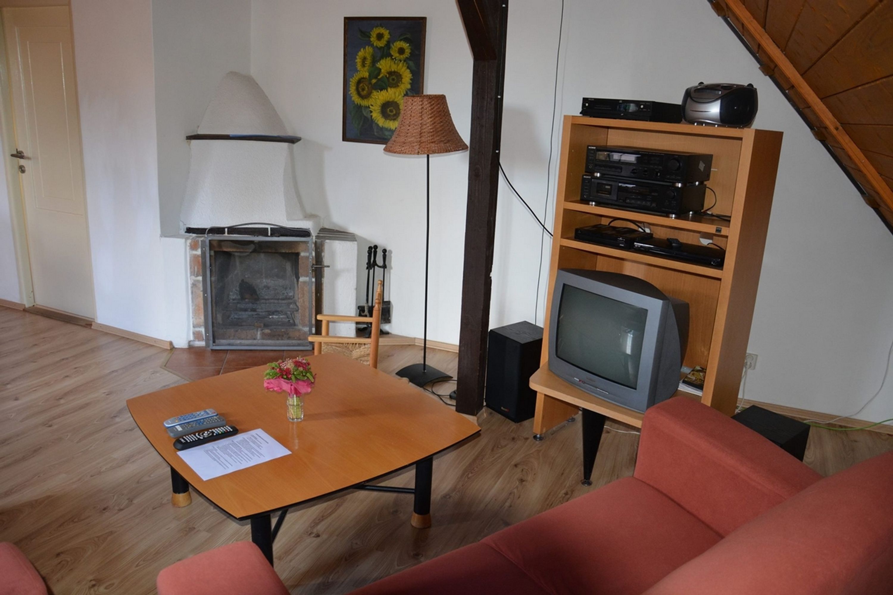 A living room with a fireplace, a television, and a wooden entertainment unit.