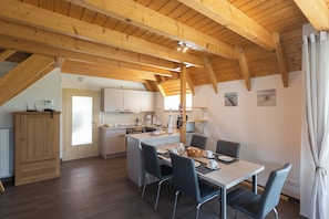 Kitchen with dining area, equipped with appliances and a table for four.