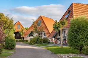 A residential area with houses featuring pitched roofs and a paved driveway.