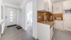 Een moderne keuken met een inbouwoven, een magnetron en een koffiezetapparaat.
