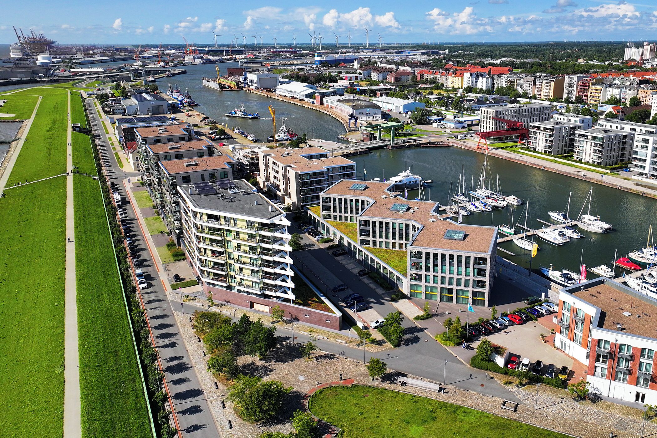 A marina with boats, a river, and buildings with balconies.