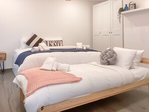 A bedroom with two beds, a wardrobe, and a nightstand. - Modern Beautiful Pool And Sea Apt Qawra (St. Paul's Bay)