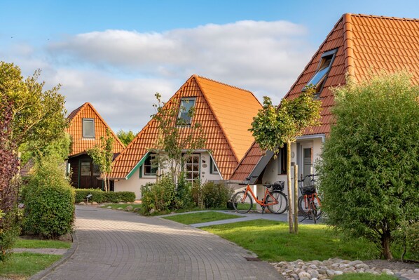 A residential area with houses featuring pitched roofs and a paved driveway.
