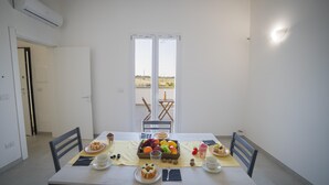 A dining area with a table set for breakfast, including fruits, pastries, and beverages. - Villa Cristal Pool and Padel (Galatina)
