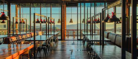 Un restaurant spacieux, doté de hauts plafonds et de grandes fenêtres offrant une vue sur les montagnes.