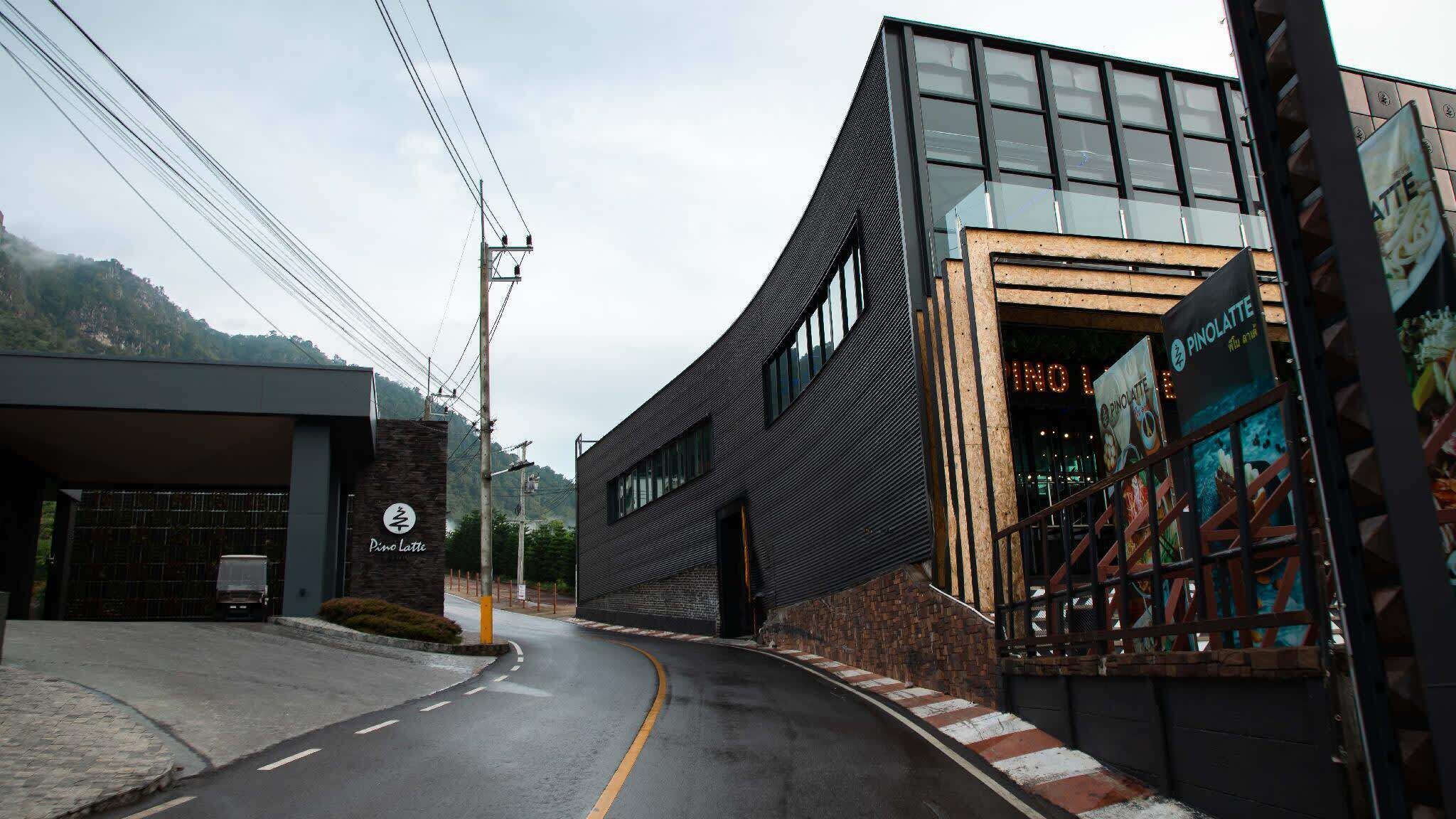 A modern building with a curved facade, a visible entrance, and a sign for 'Pino Latte'.