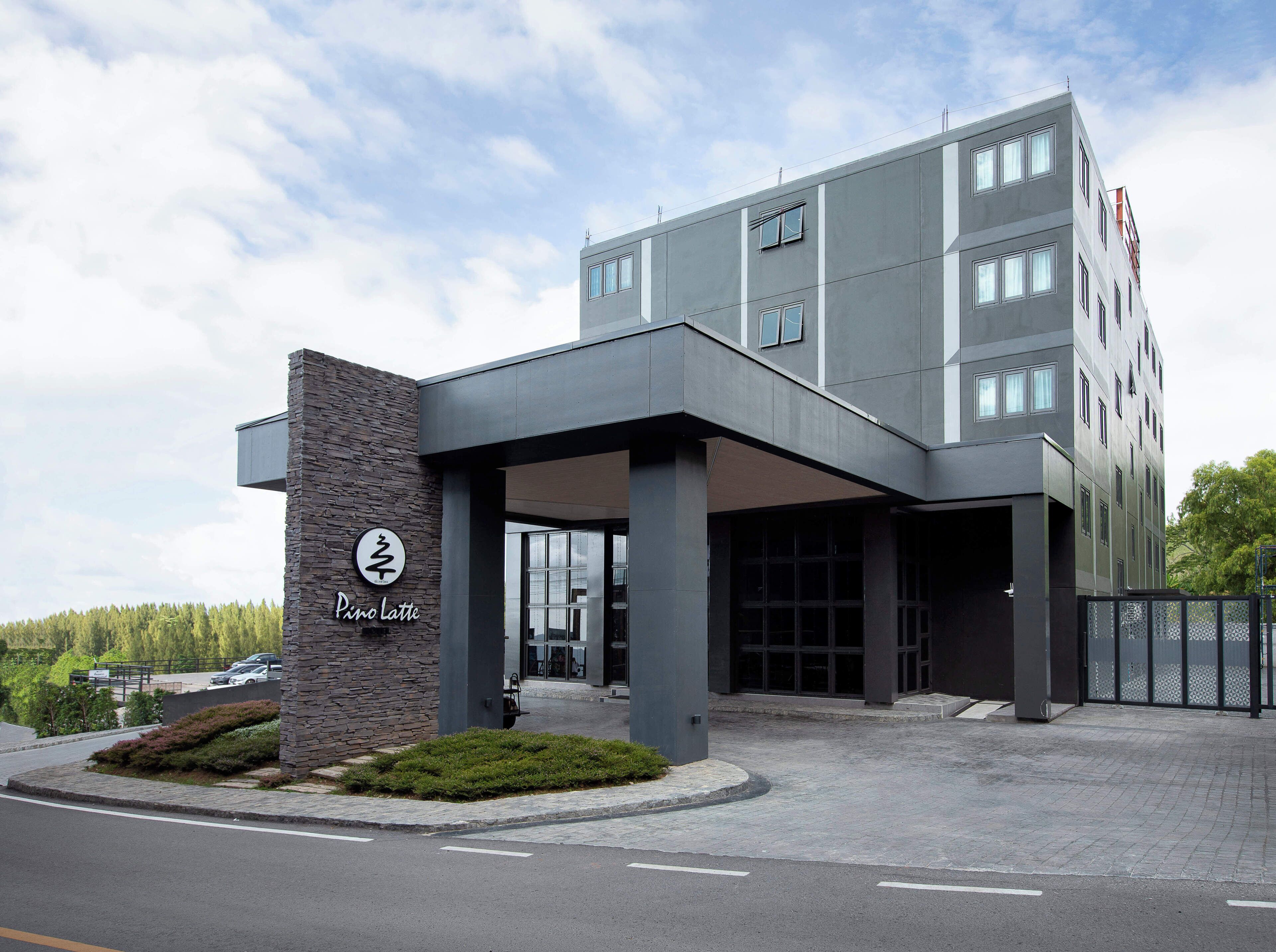 Un bâtiment moderne avec une façade en pierre et une enseigne indiquant « Pino Latte ».
