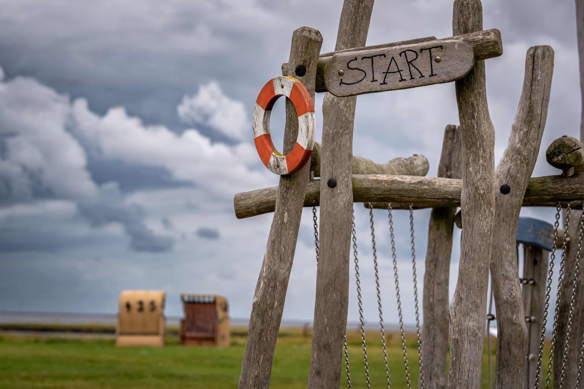 A wooden gate with a 'START' sign and a lifebuoy attached to it.
