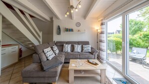 Un salon moderne avec un canapé, une table basse et un escalier.