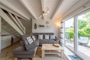 Una sala de estar moderna con un sofá, una mesa de centro y una escalera.