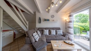 Un salon confortable avec un canapé, une table basse et un escalier.