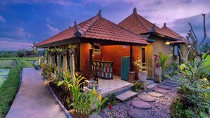 A traditional house with a tiled roof, a garden with a pathway, and a small outdoor seating area.