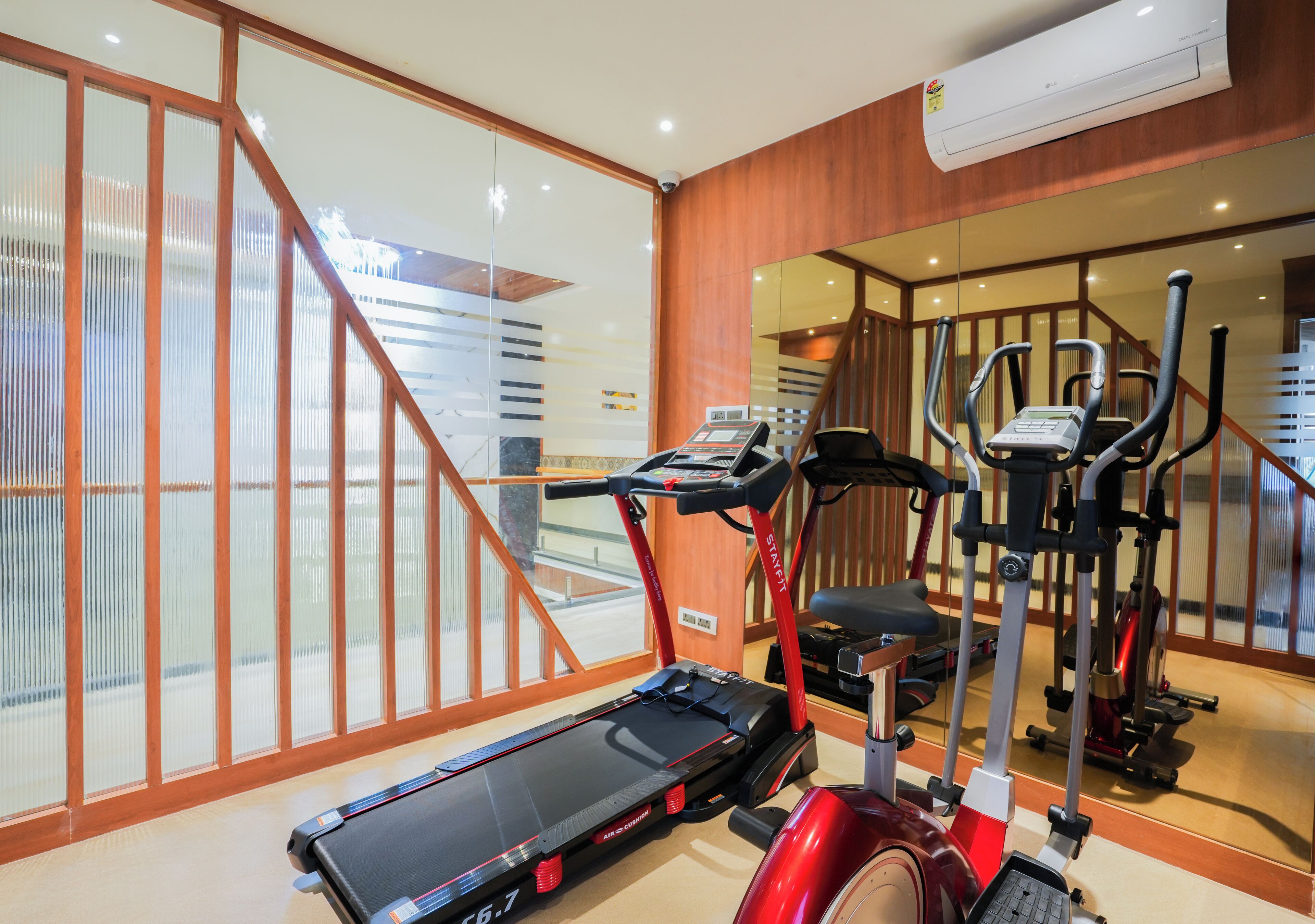 A gym with a treadmill, elliptical, and stationary bike.