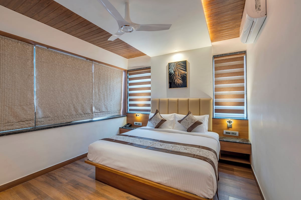 Une chambre d’hôtel moderne avec un grand lit, un plafond en bois et un ventilateur de plafond.