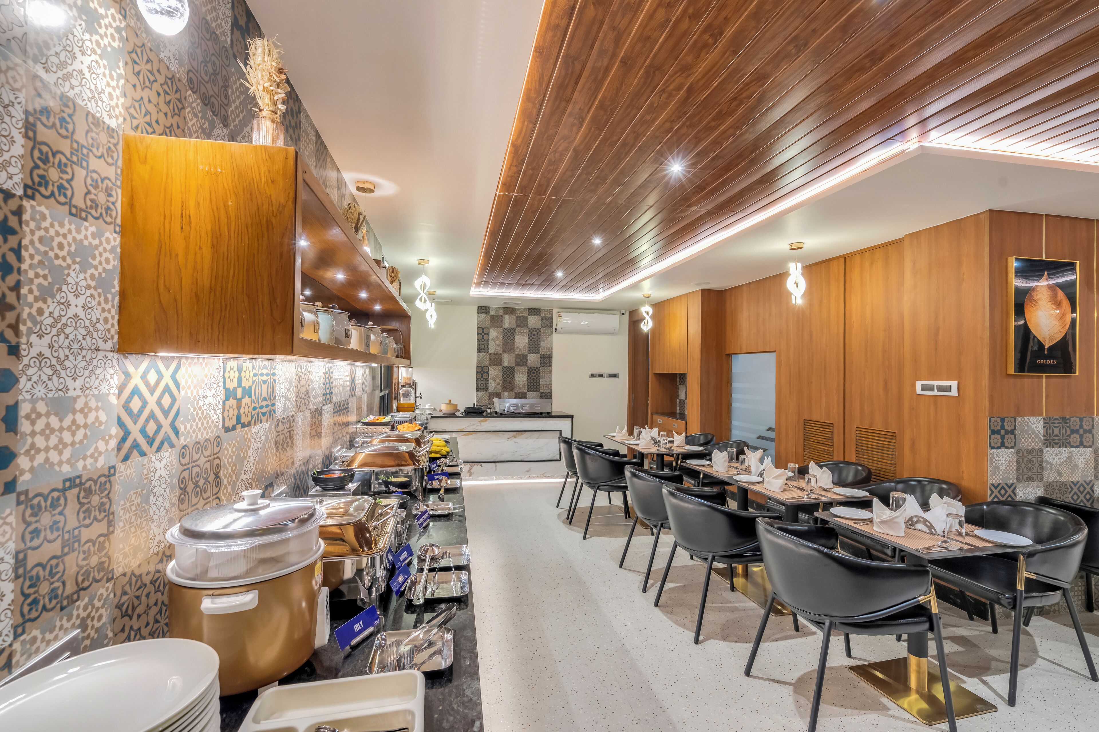 Un restaurant moderne avec un long comptoir, des chaises noires et une grande variété de plats.