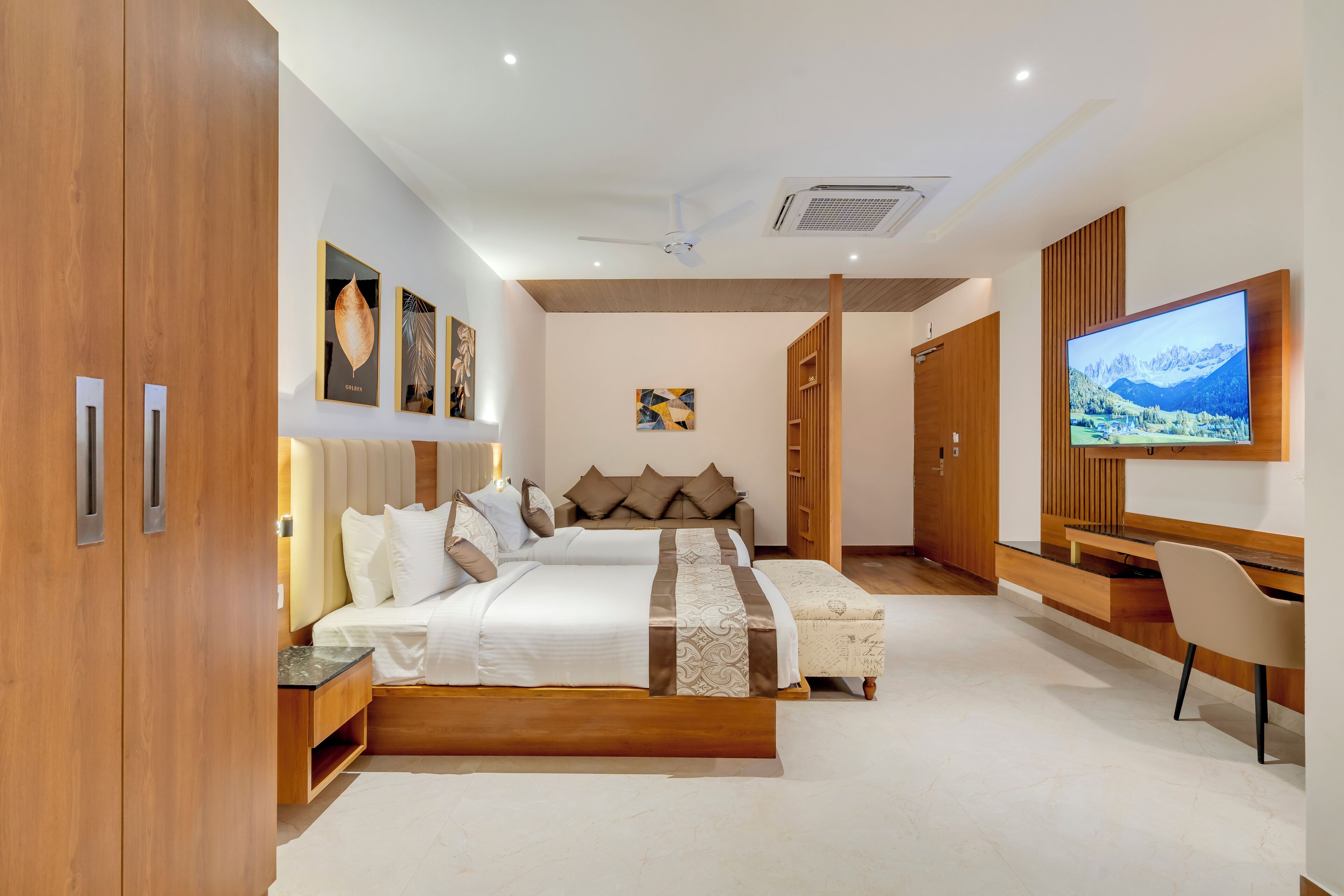 A modern bedroom with a large bed, a TV, and a desk.